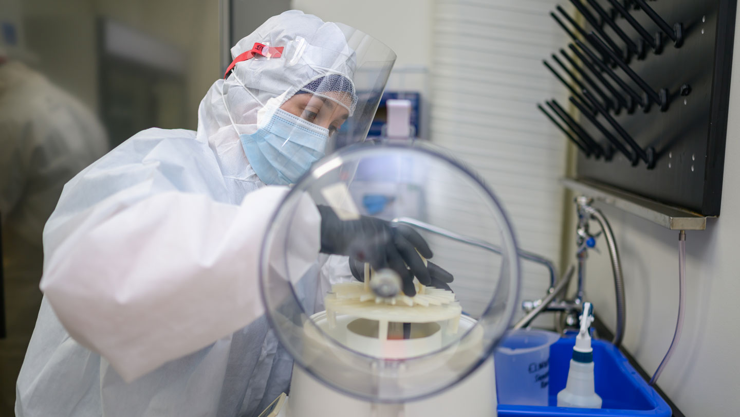 Investigadora protegida contra contaminación manipula muestras de heces antiguas de ardilla en un laboratorio