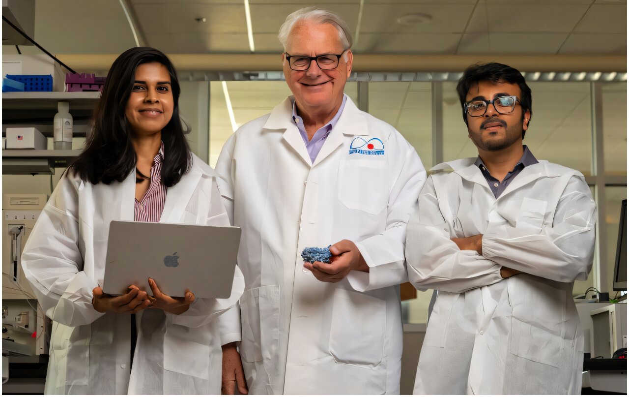 James Sacchettini y dos integrantes de su equipo posan con batas en un laboratorio donde desarrollan herramientas de inteligencia artificial para buscar fármacos contra la tuberculosis.