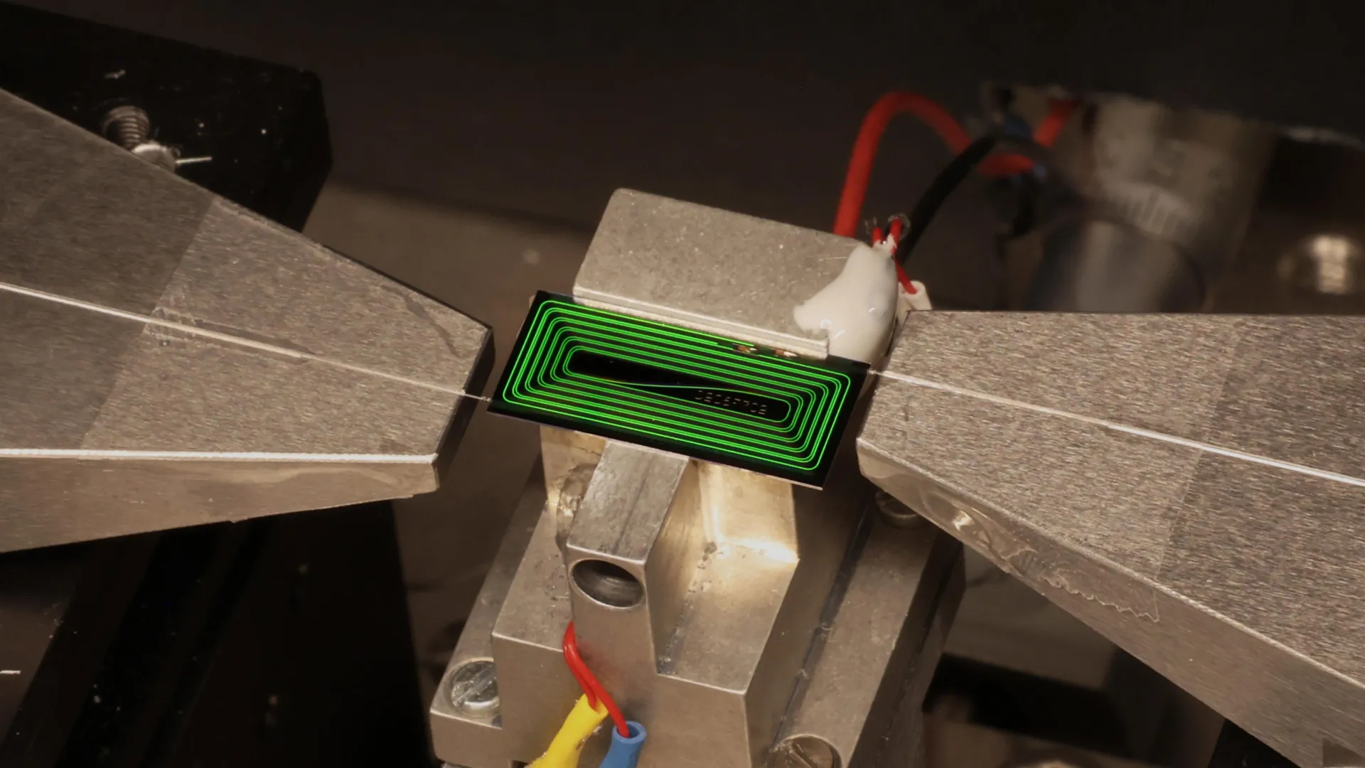 Montaje de laboratorio con un chip fotónico conectado a un sistema óptico para generar pulsos láser ultrarrápidos