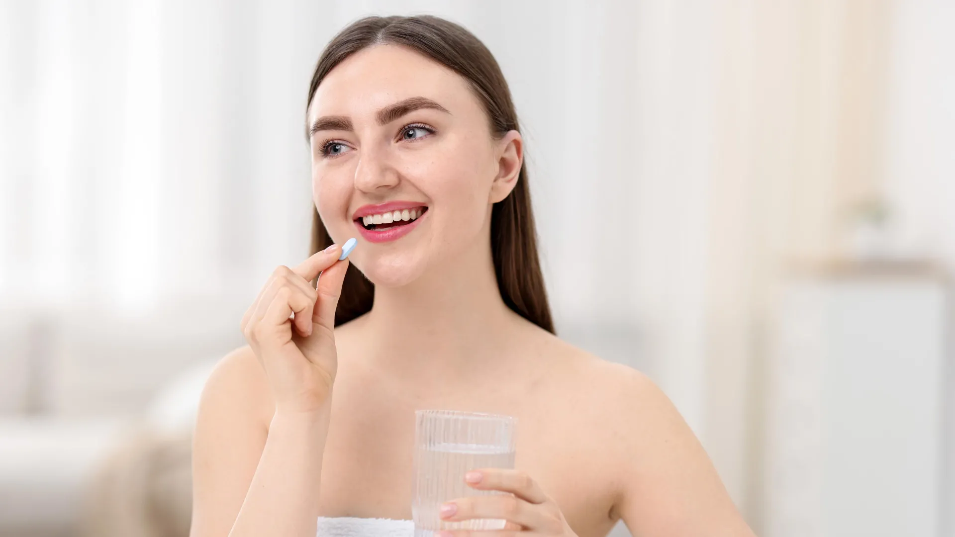 Mujer tomando un comprimido como ilustración de una nota sobre suplementos de colágeno