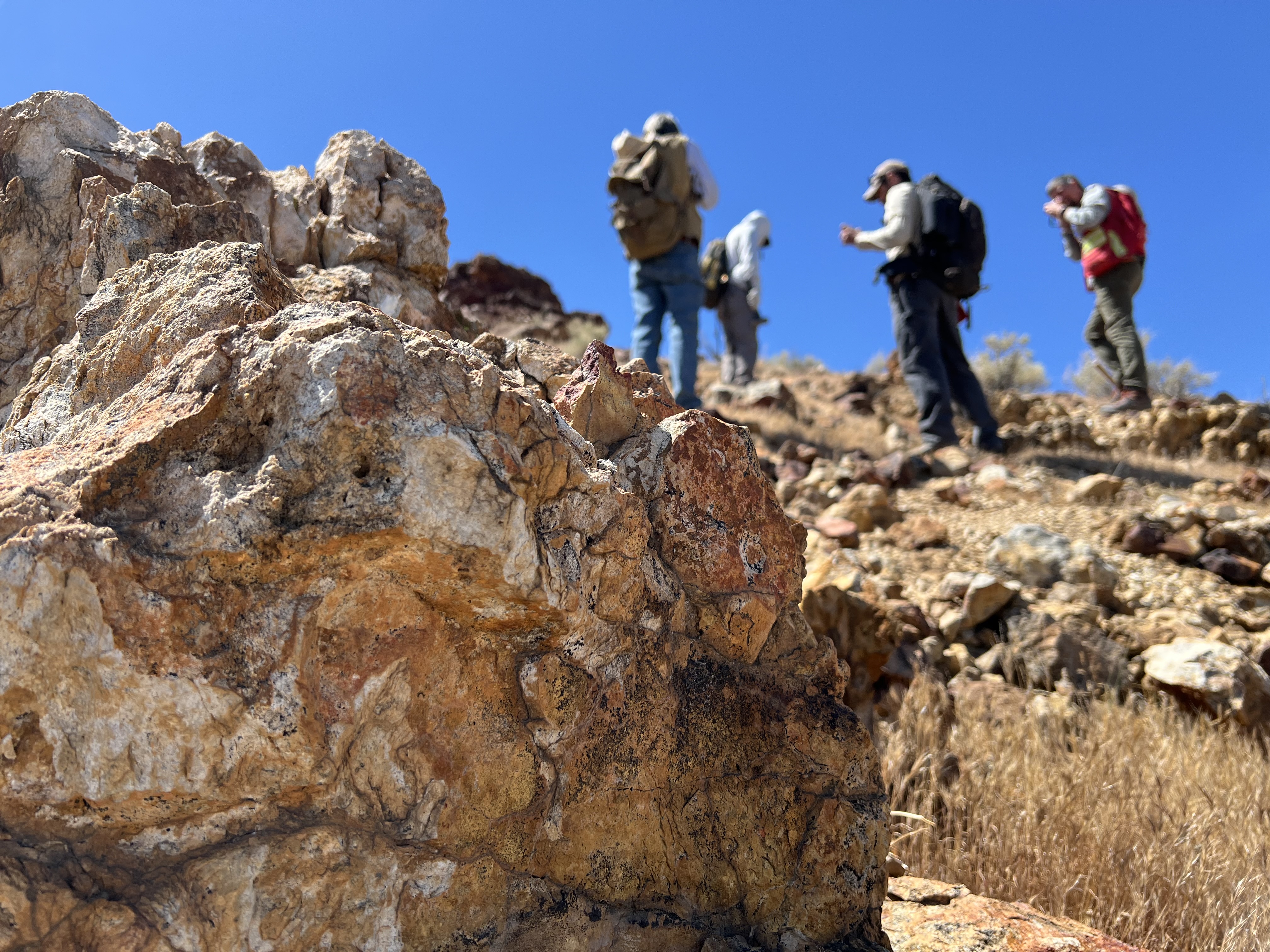 Geólogos examinan afloramientos rocosos en una ladera del desierto de Mojave durante una campaña para verificar señales minerales detectadas desde el aire